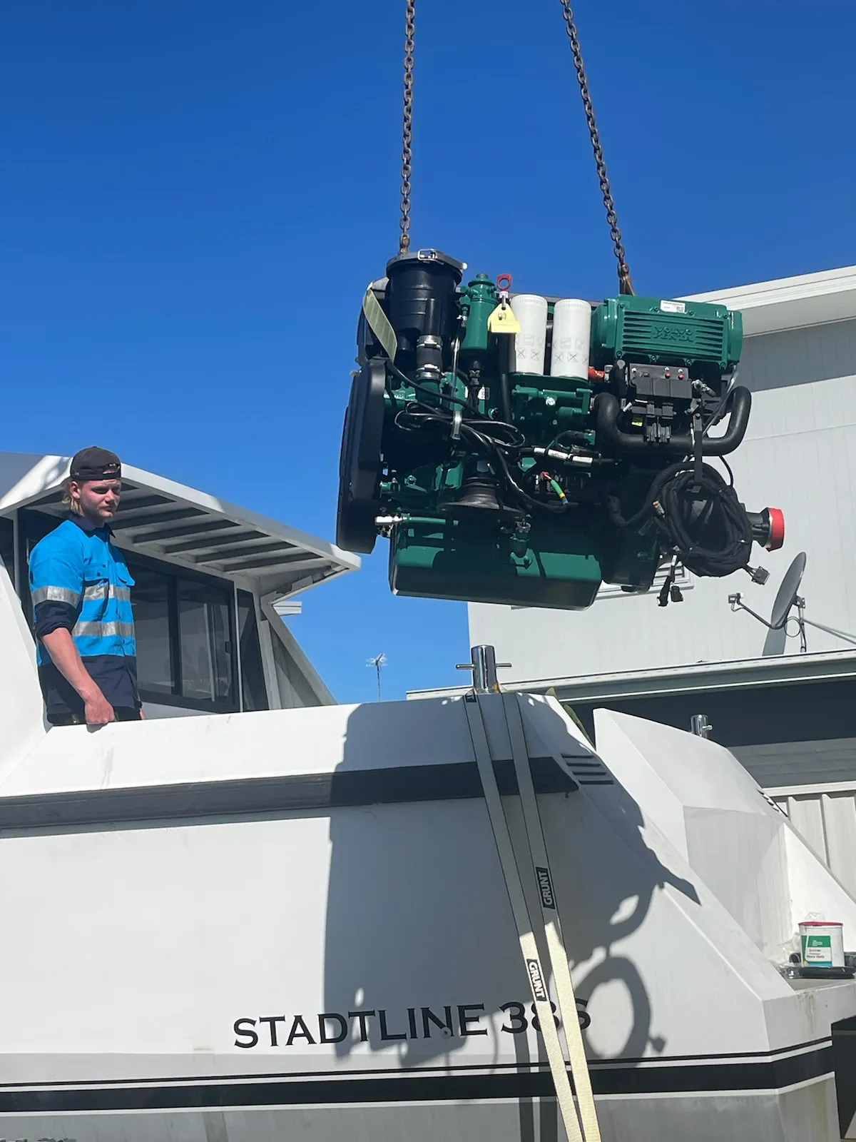 Volvo Penta D4 suspended from crane above the hull