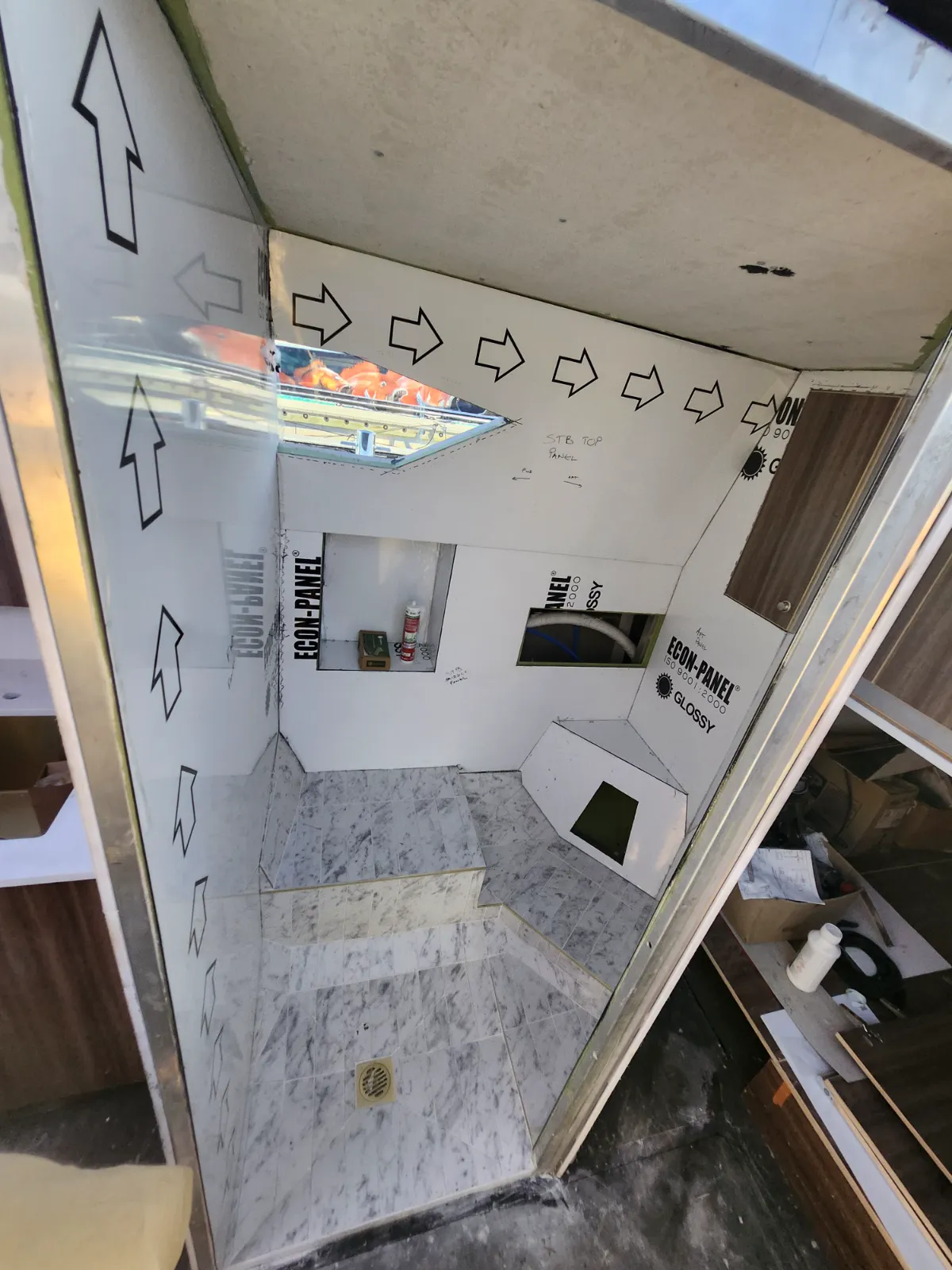 Econ-Panel wall linings going in — marble floor complete, skylight framed