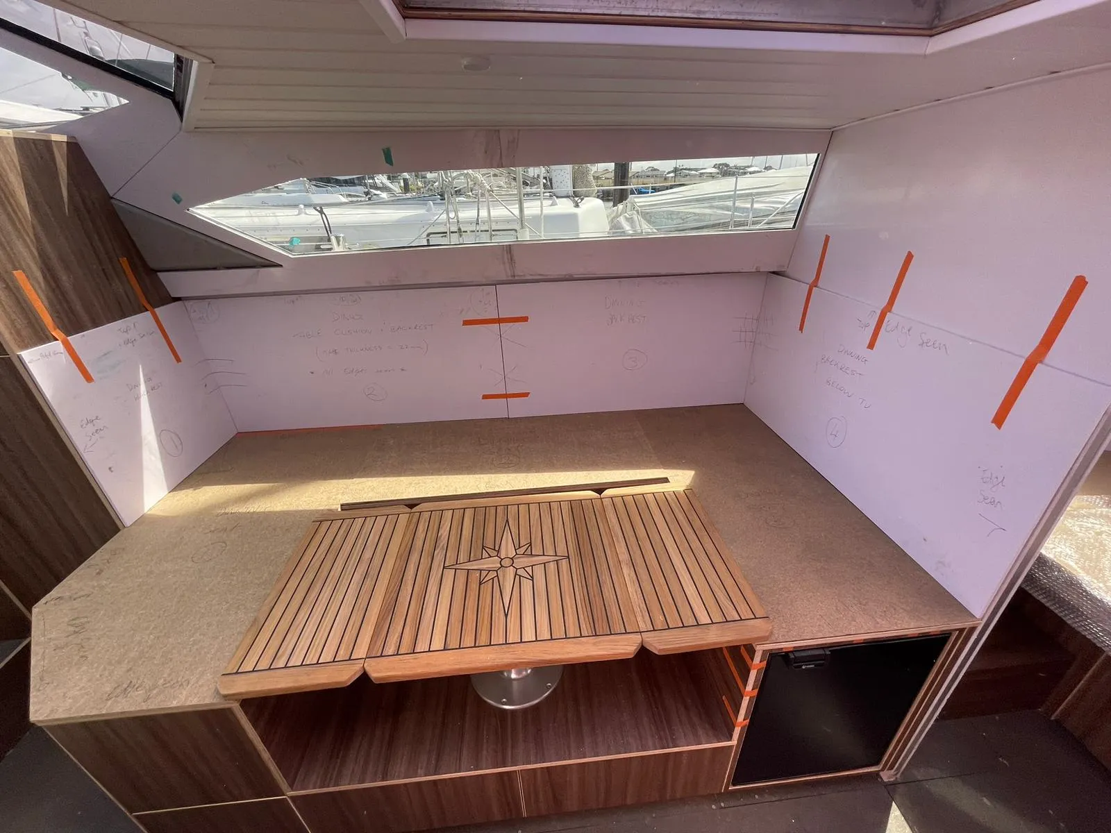 Saloon interior with teak table and MDF seat templates taped in position
