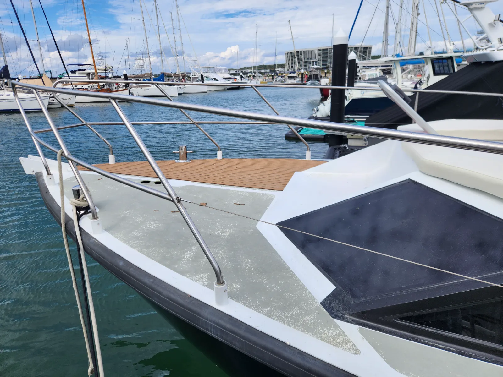 Bow section with teak section installed alongside bare aluminium deck still to be covered