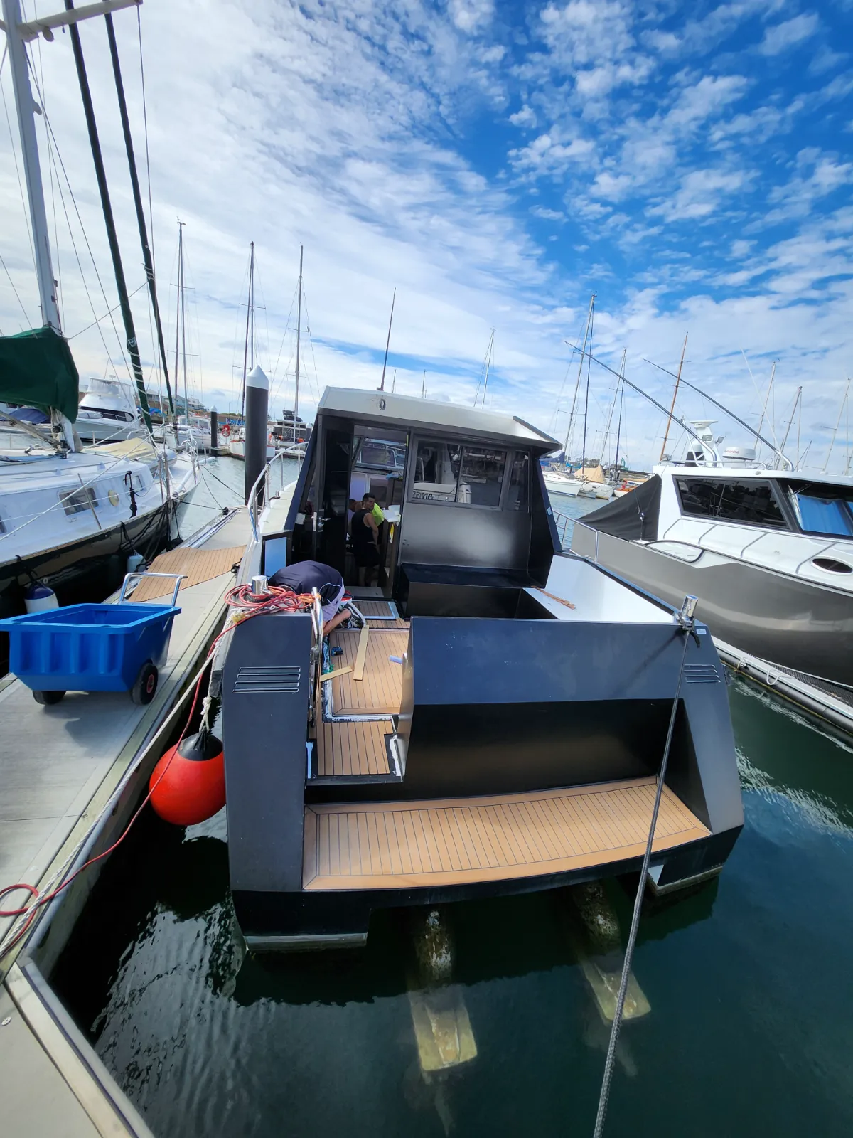 Stern and swim platform with teak fully laid — team working in cockpit