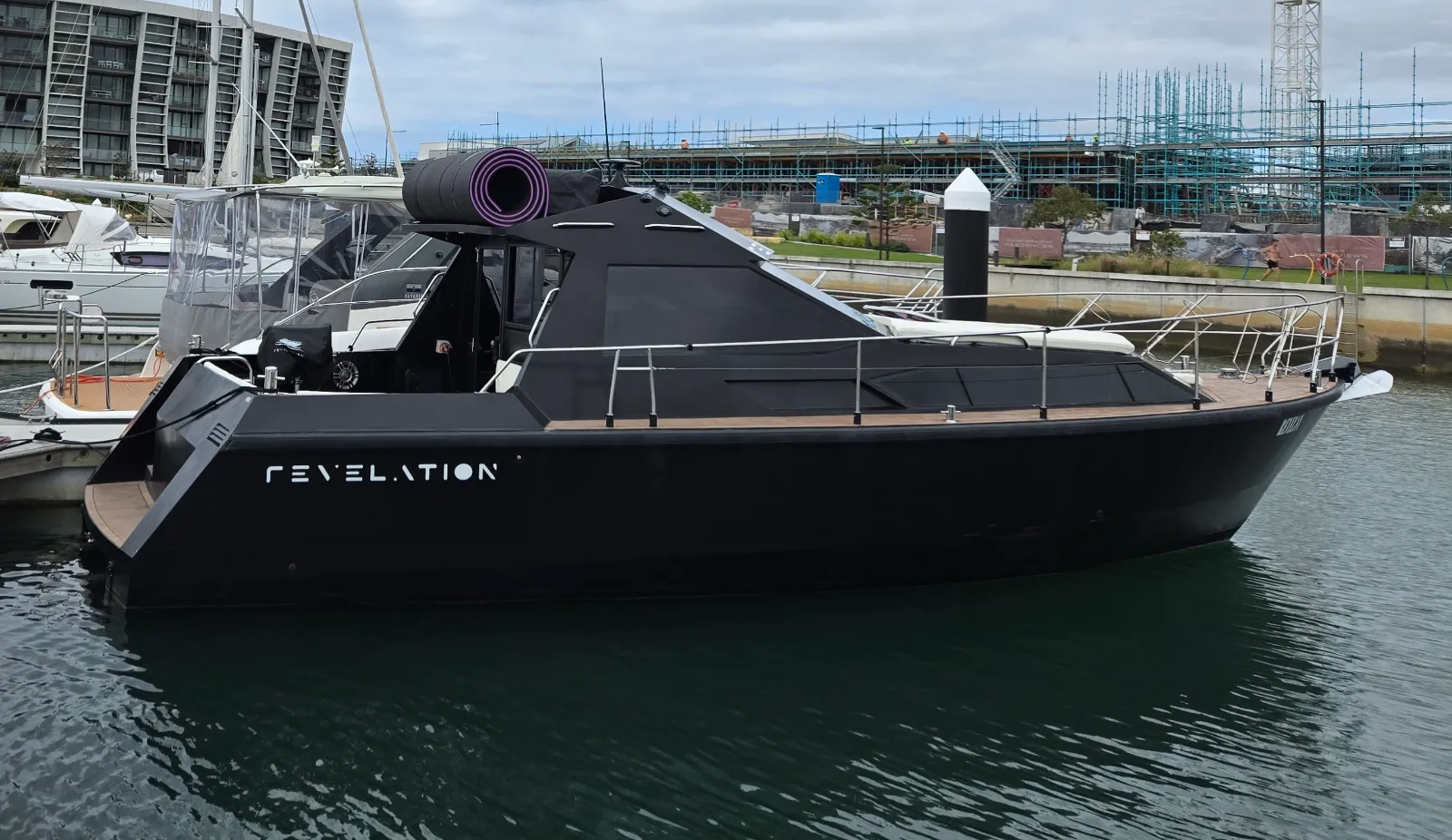 Revelation three-quarter profile — full satin black exterior complete at marina