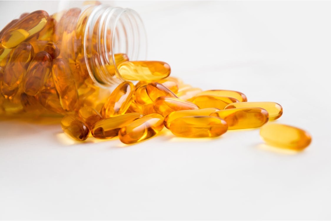 Fish oil softgels and bottle, illustrating omega-3 as a common addition to recovery routines