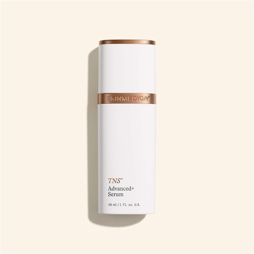White SkinMedica TNS Advanced+ Serum bottle with bronze accents on a cream background