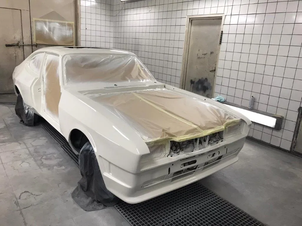The Capri shell masked up in the spray booth, front three-quarter view