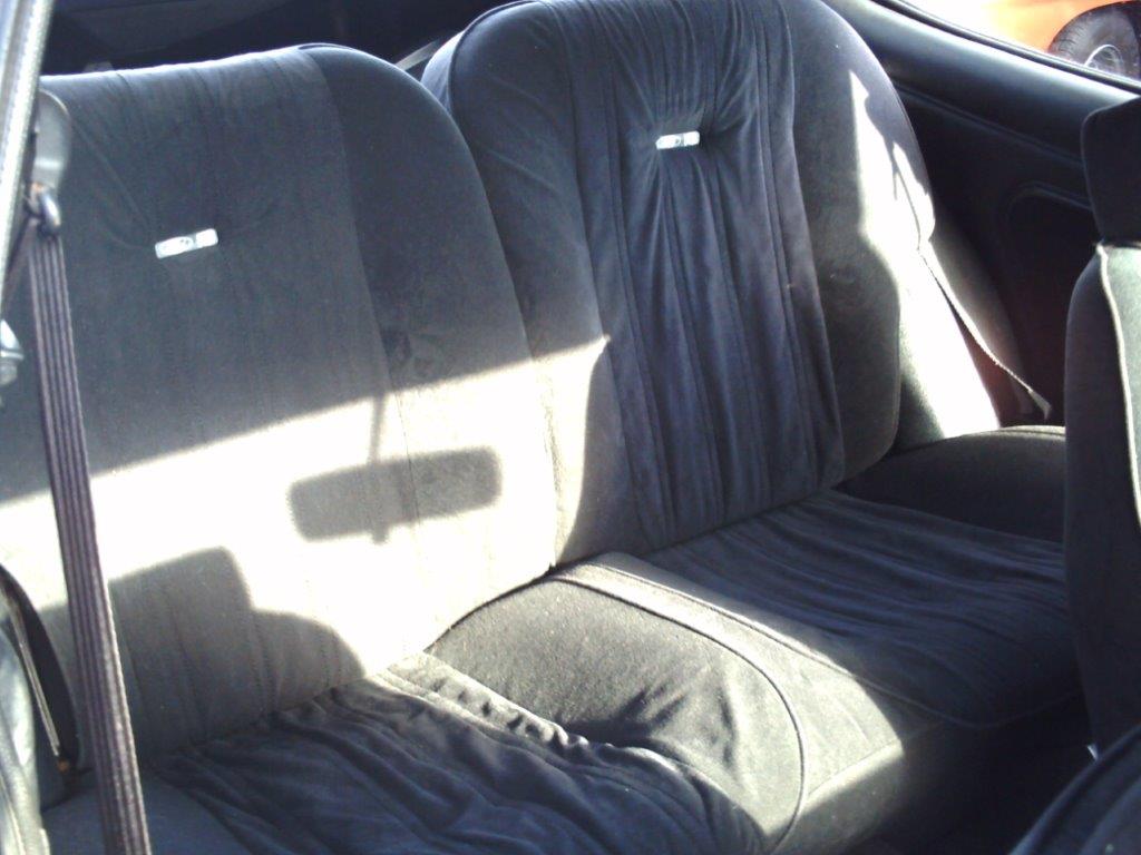 The original rear seats in dark cloth trim, photographed before the restoration