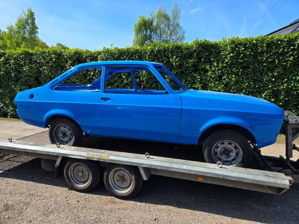 The Ford Escort Mk2 in blue paint on the trailer, front three-quarter view