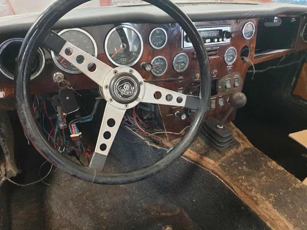 The original interior of the Lotus Elan 2+2: wooden dashboard, full instrument set, Lotus steering wheel and loose wiring