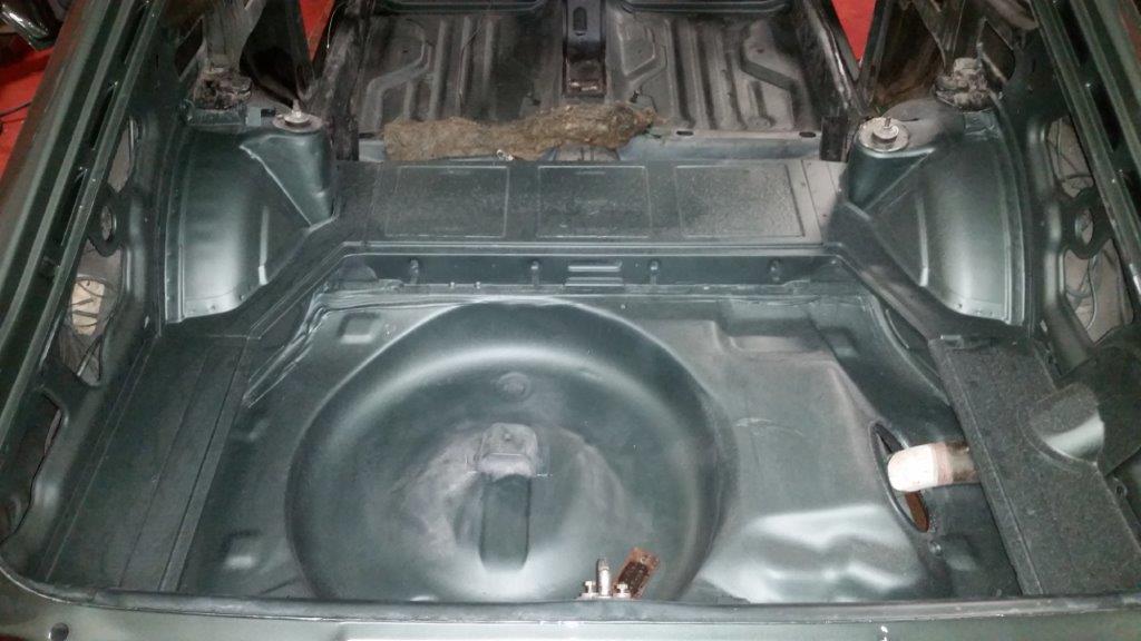 The bare boot floor and spare wheel well after the shell was stripped