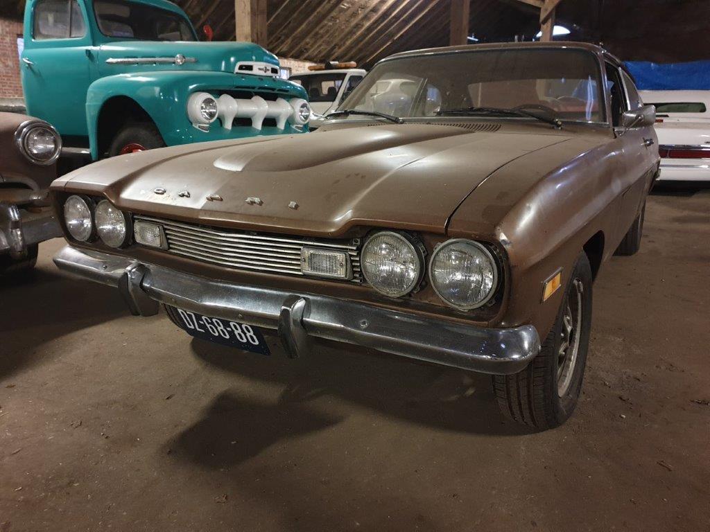 The Capri Mk1 2000GT USA from the front three-quarter, standing between other cars in storage