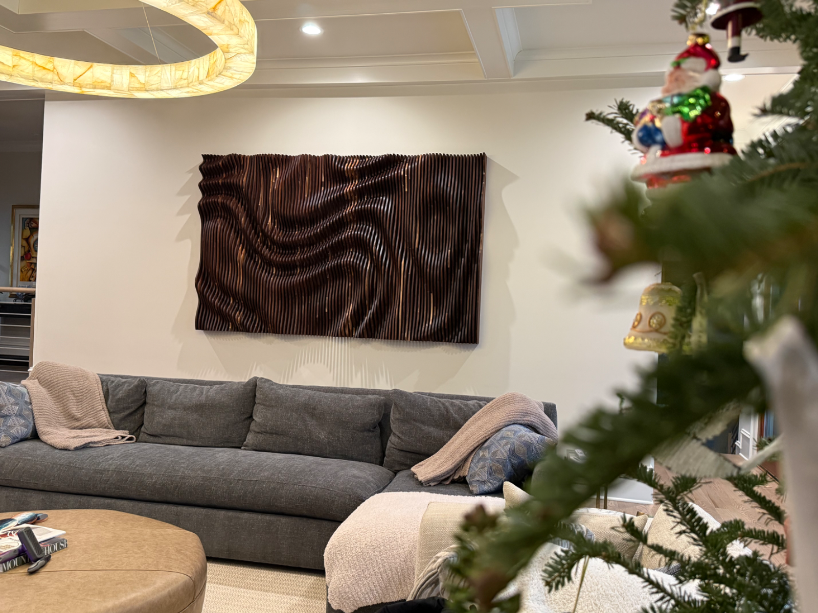 A walnut wall sculpture installed above a sofa in a private residence