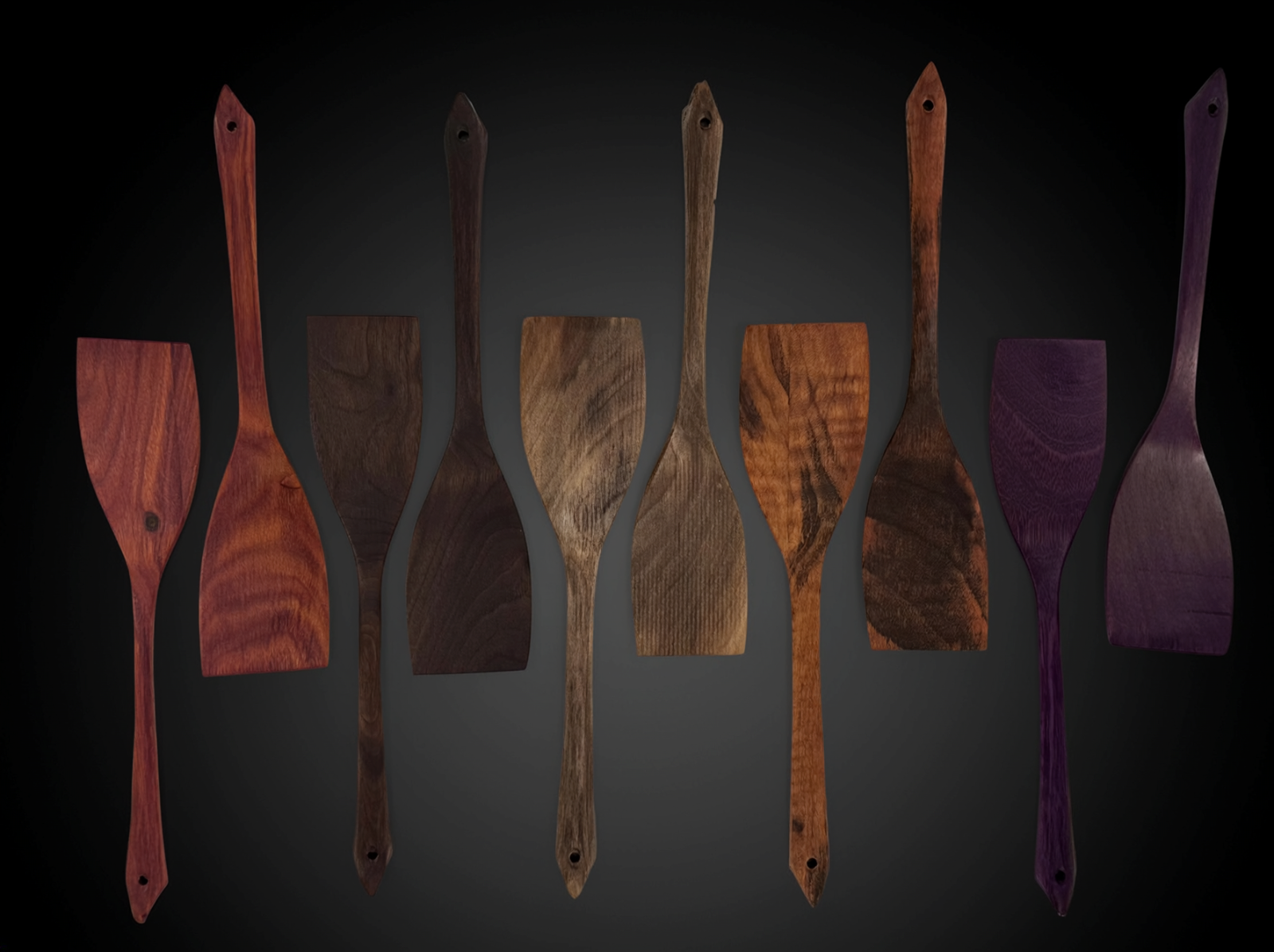 Ten hand-cut wooden servers in five exotic wood species, laid in a row