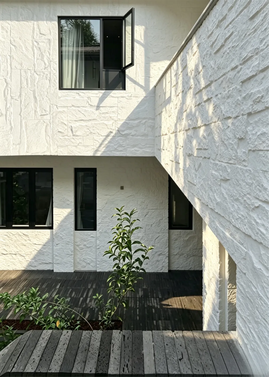 Textured white exterior wall finish with architectural shadows