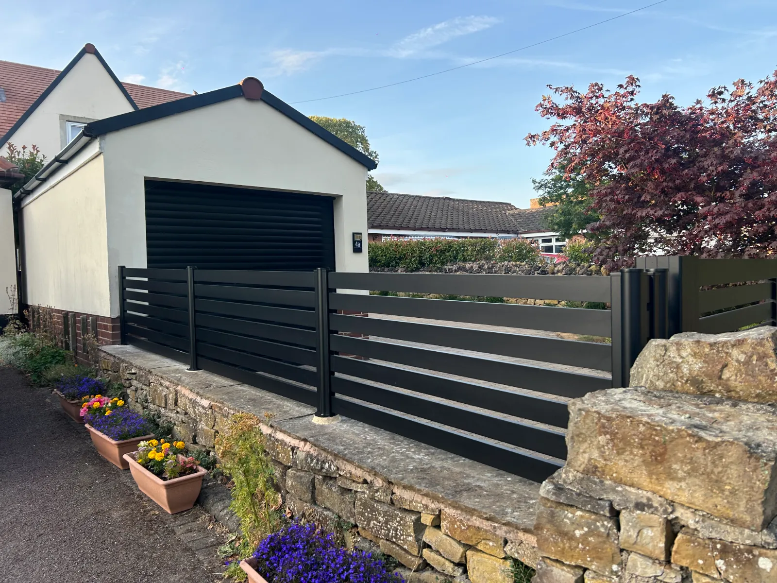 Slatted fence and gate / stone wall